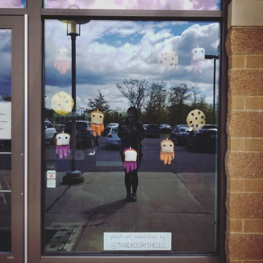 Storefront art installation with handmade cookie and sandwich plushies