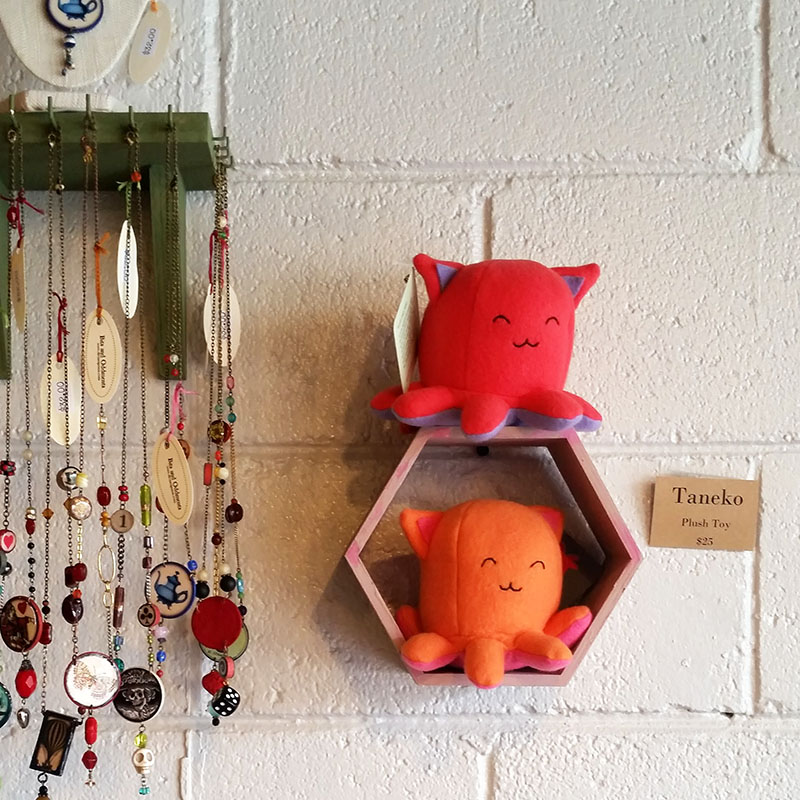 2 Taneko plushies sitting on a hexagon wall shelf