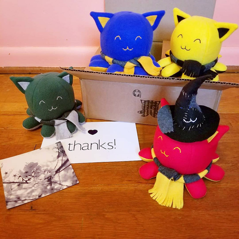 4 Tanekos cosplaying as the Hogwarts houses