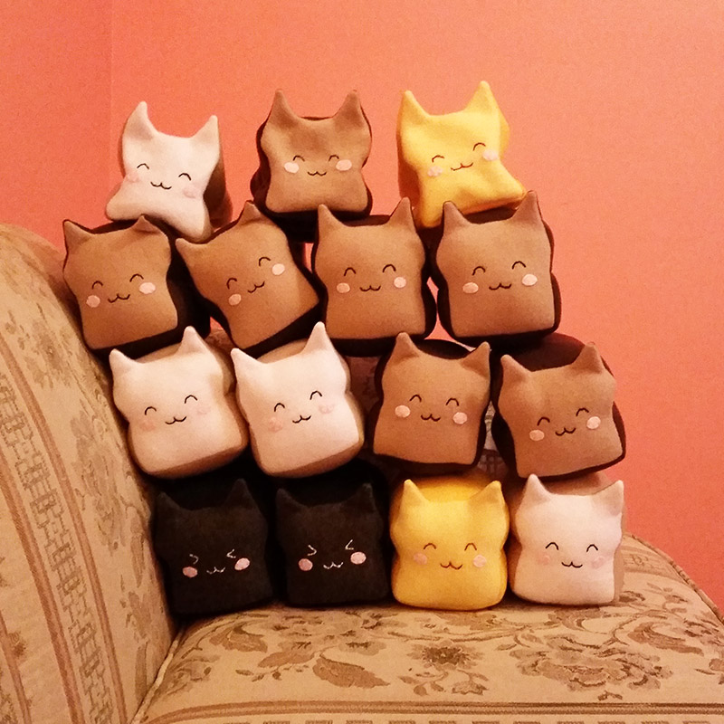 stack of 15 Meow-Bao plushies on a couch
