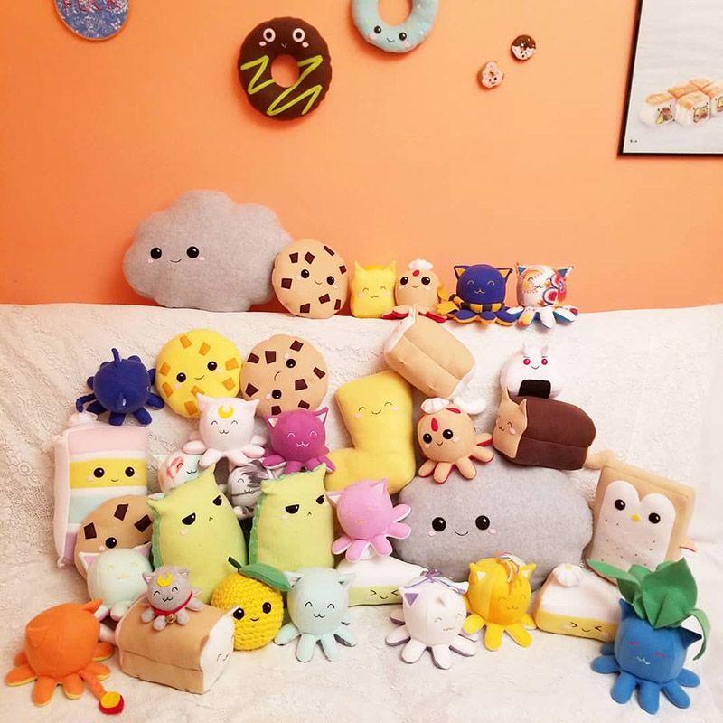 cute handmade plush toys sitting on a couch with a coral wall backdrop