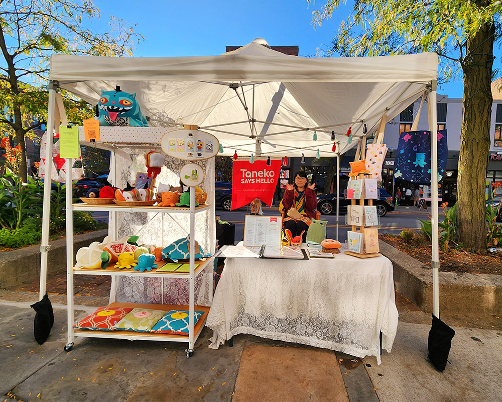 Taneko Says Hello outdoor booth display at Vault of Midnight