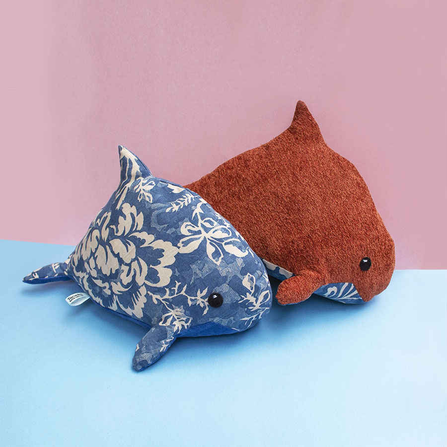 two Repurposed Porpoise eco-friendly plush toys handmade by Sophia Adalaine on blue and pink backdrop
